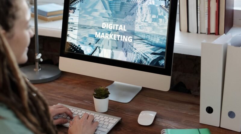 Mulher sentada com o computador aberto na pagina de Marketing Digital