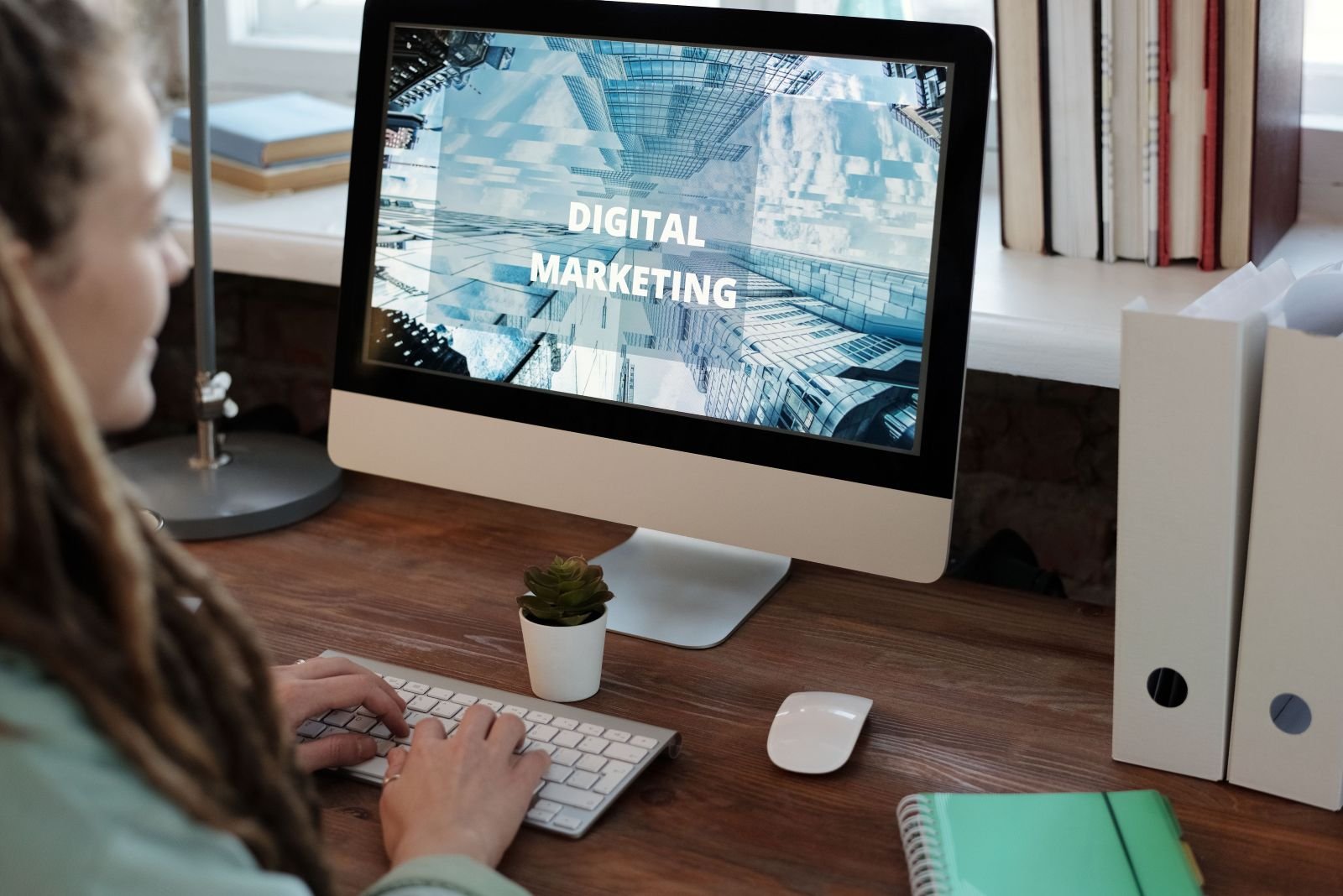 Ferramentas IA para Marketing Digital: 9 Opções que Podem Aumentar a Produtividade Mulher sentada com o computador aberto na pagina de Marketing Digital