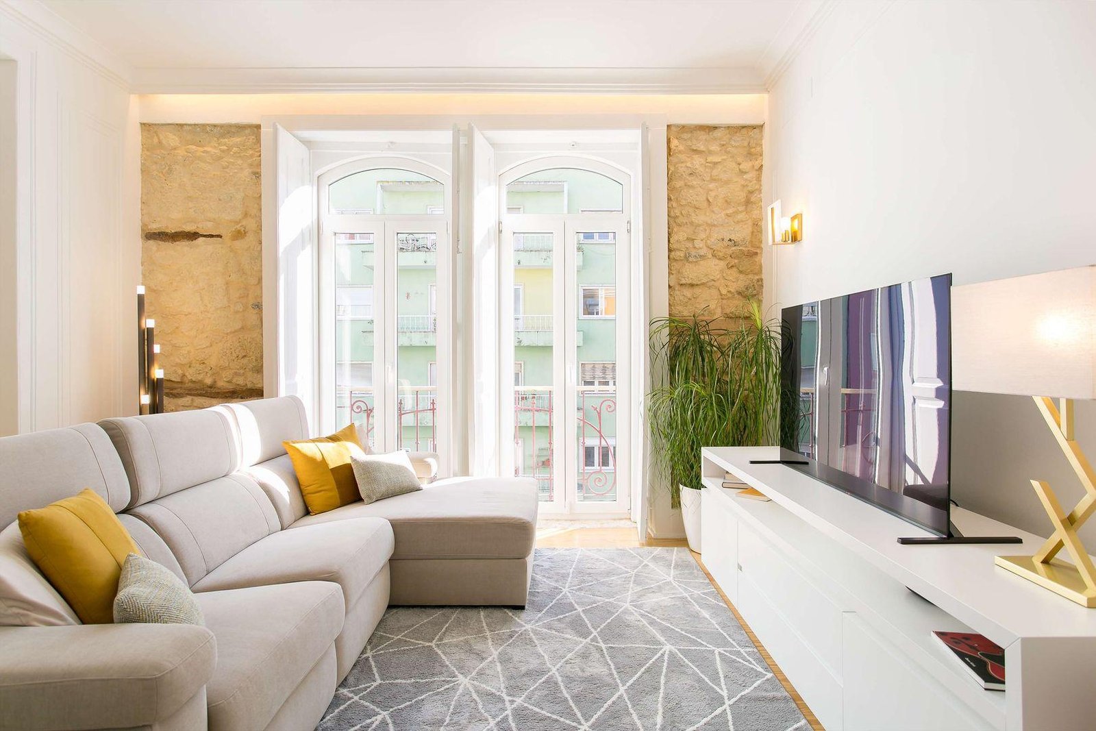 Sala com luz natural e decorada com tons neutros e amarelo