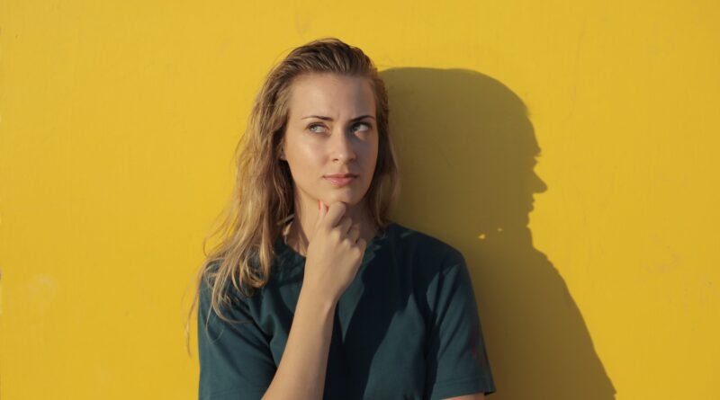 Mulher a olhar para o lado e com um ar pensativo
